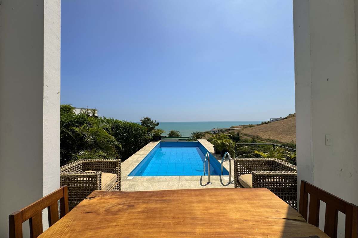 Une vue sur une piscine, avec un ciel dégagé et un paysage lointain.
