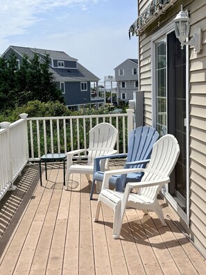 A wooden deck with two white Adirondack chairs and a small table, overlooking a residential area. - 2 blocks to Roger Wheeler Beach 4-bedroom house perfect for your Summer getaway! (Narragansett)