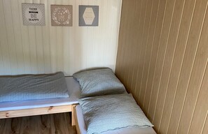 A small, single-bed room with a wooden headboard and a wall-mounted bed. There are three framed motivational quotes on the wall. - Room for 2 People With Kitchenette (Mielno)