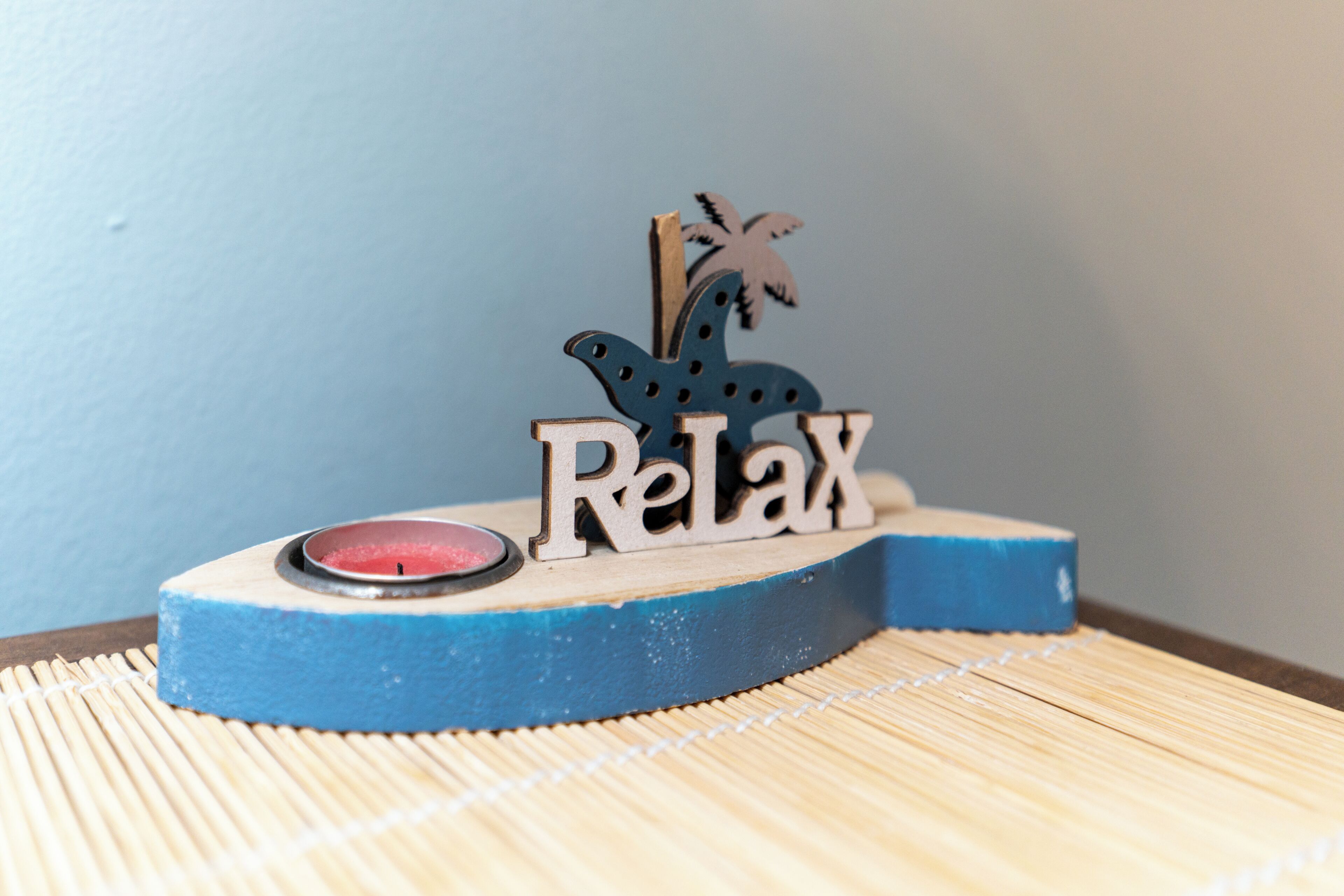 A wooden block with the word 'Relax' and a small figurine of a turtle on top.