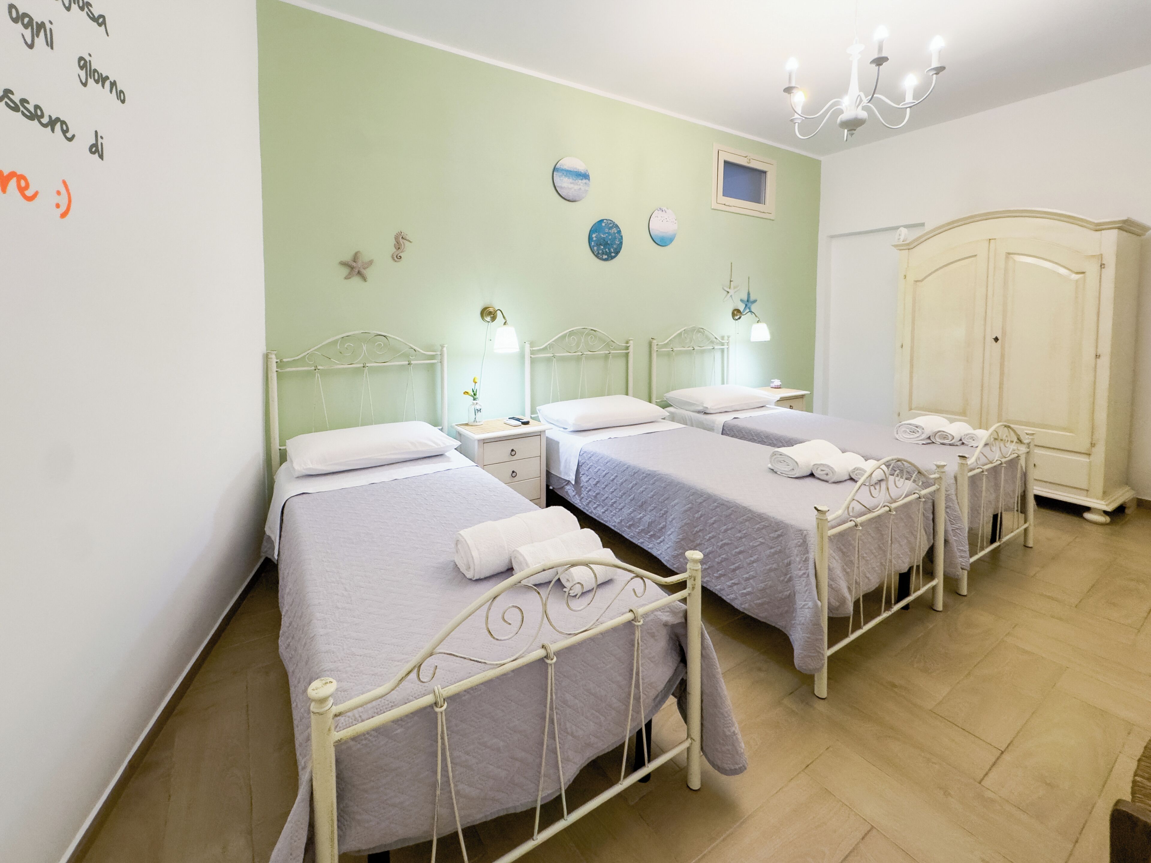 Habitación de hotel con dos camas, un armario y una pared decorada.