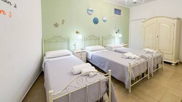 Een hotelkamer met twee bedden, een kast en een muur met decoratieve objecten.