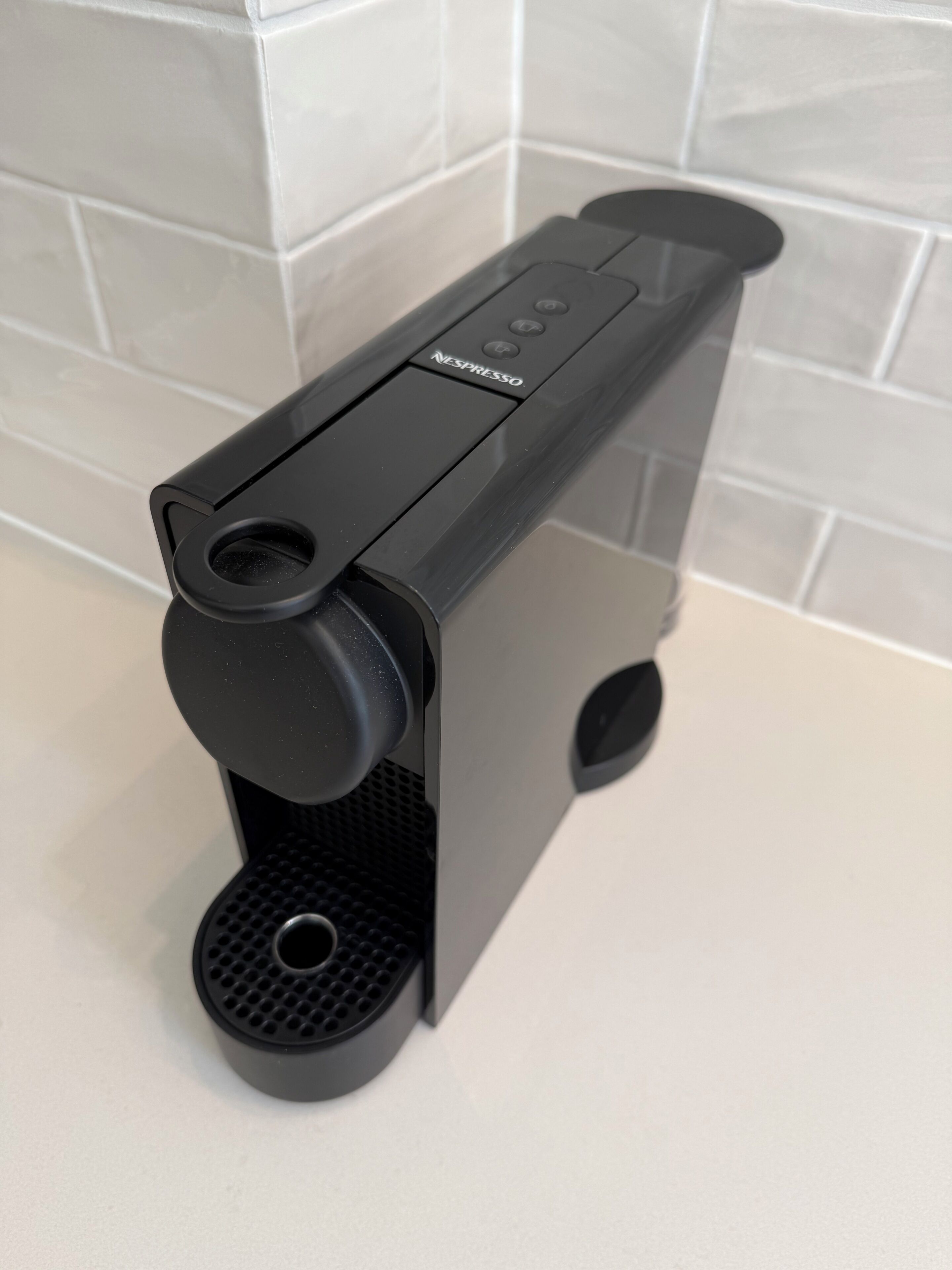 A black coffee machine with a control panel on a countertop.
