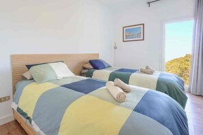 A bedroom with two beds, each with a headboard, a bedside lamp, and a view of the outdoors. - Serendipia · Private Pool · Nature and Ocean Views (CN)