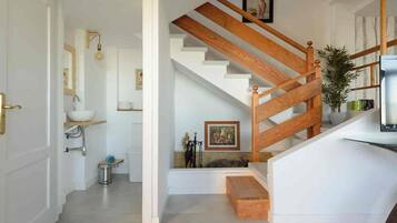 Una escalera con barandas de madera y una pared blanca.