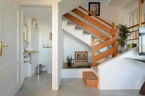 A staircase with wooden railings and a white wall.