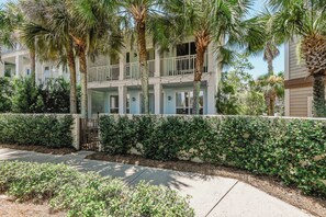 A multi-story hotel with balconies, a hedge-lined driveway, and palm trees. - Poolside Paradise - Access To Pool, Walk To Beach! (Rosemary Beach)