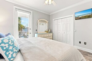 A bedroom with a bed, dresser, and a large window with blinds. - Poolside Paradise - Access To Pool, Walk To Beach! (Rosemary Beach)