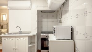 Eine Küche mit weißen Schränken, einer Spüle, einem Herd und einem Kühlschrank.