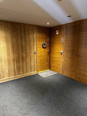 Ein Zimmer mit Holzvertäfelung, einer Tür mit Nummernschild und einer Fußmatte.
