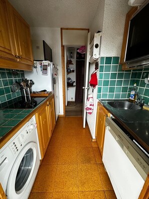 A compact kitchen with a washing machine, a dishwasher, and a microwave. - Meribel Mottaret Apartment at the Foot of the Slopes, Sleeps 5, All-Inclusive (Les Allues)