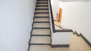 Eine Treppe mit Handlauf, die zu einer Zwischenebene mit einer Tür führt.