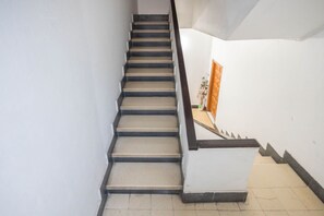 A staircase with a handrail, leading to a landing with a door. - 3-Bedroom Urban Apartment - Central & Comfortable (Las Palmas de Gran Canaria)