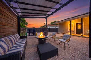 An outdoor patio with a fire pit, seating, and a pergola. - Apple Street Getaway - Fire Pit & Close to Main St (Fredericksburg)