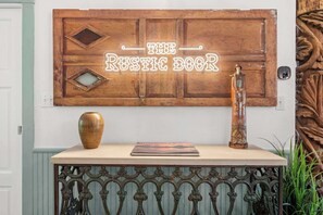 Wanddeko im rustikalen Stil mit dem Text 'THE RUSTIC BOOK' und einer dekorativen Vase auf einem Tisch.