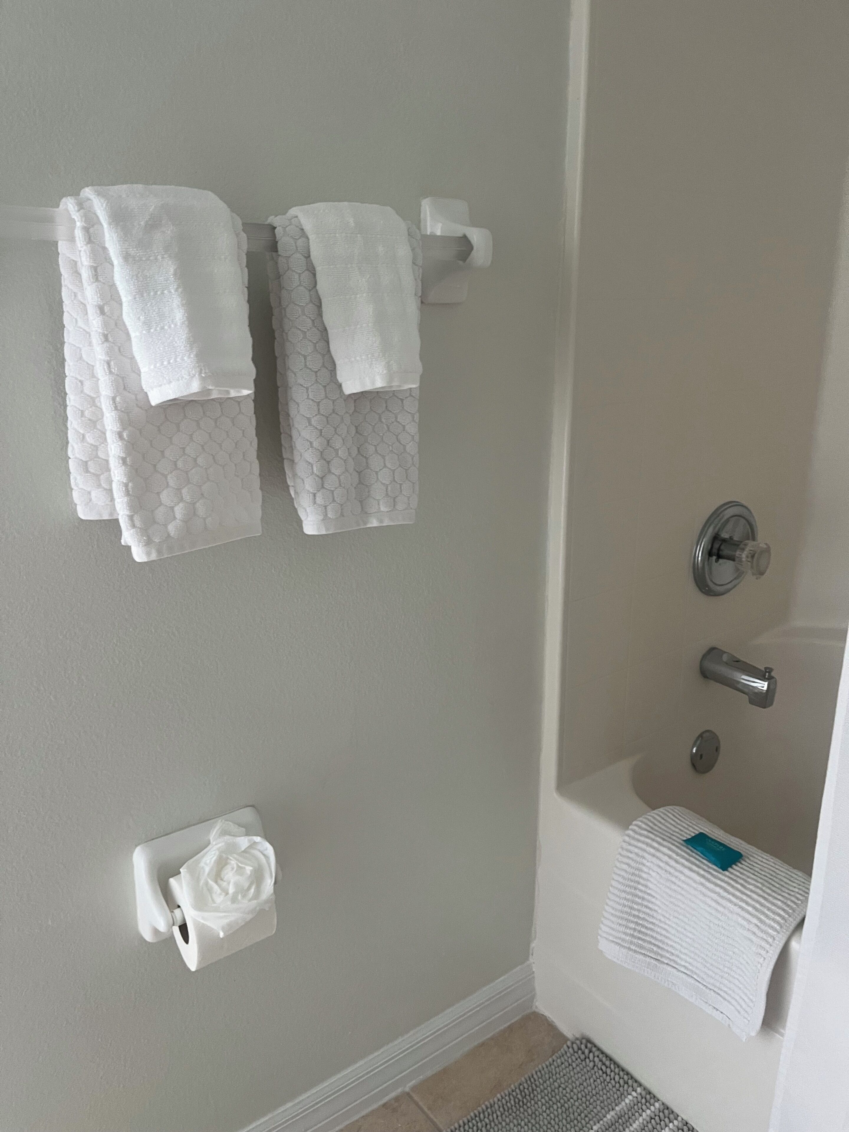 Une salle de bain équipée d’une baignoire, de toilettes et de deux porte-serviettes avec des serviettes.
