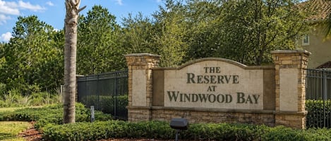 A sign for 'The Reserve at Windwood Bay' with a stone wall and metal gate.