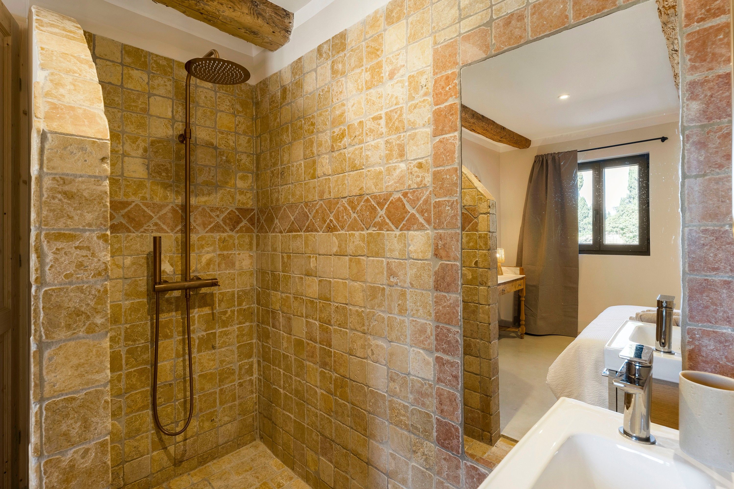Une salle de bain avec une douche, un lavabo et une fenêtre.