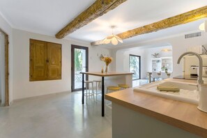 Eine moderne Küche mit einer zentralen Kochinsel, Holzschränken und einem großen Fenster.