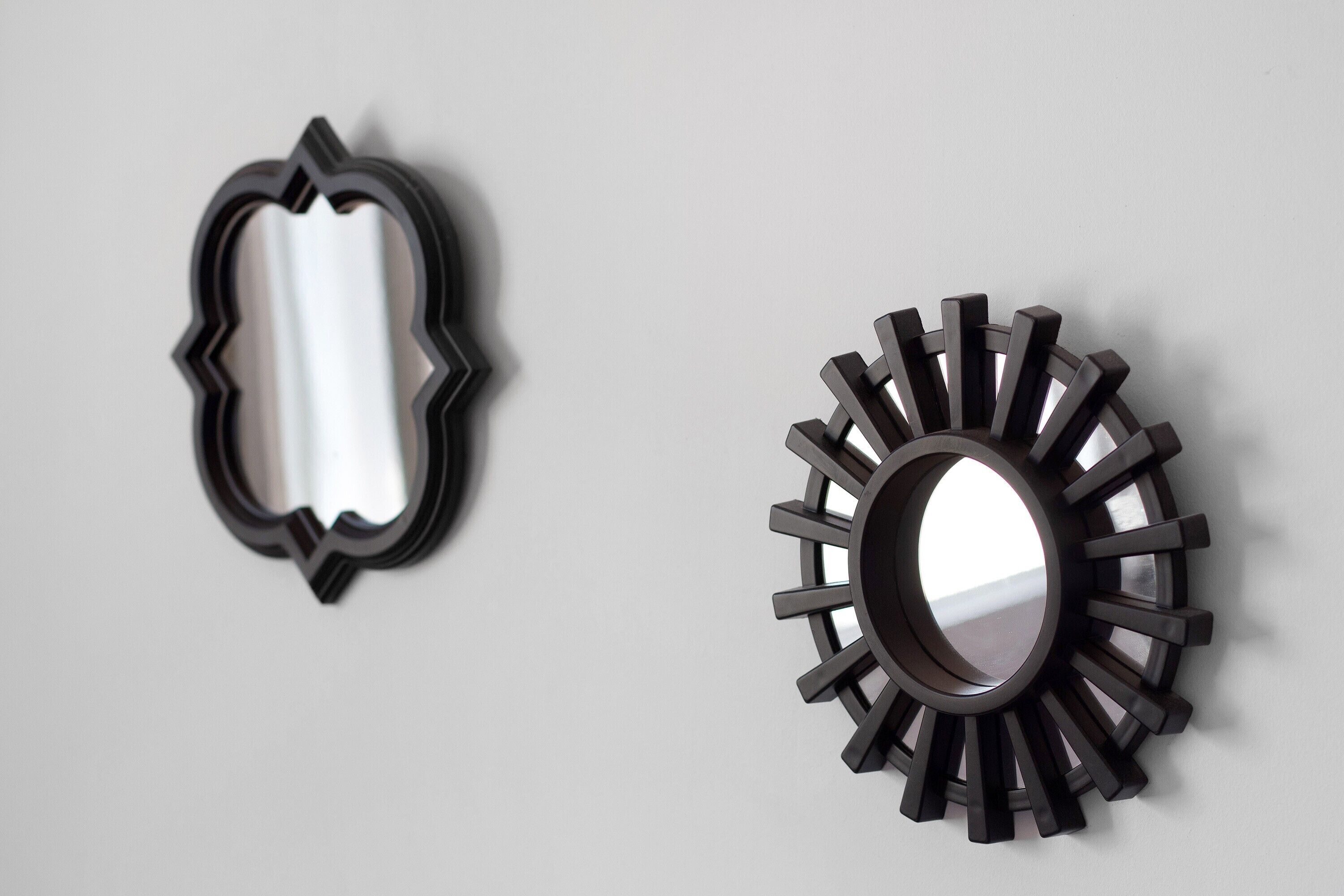 Two wall-mounted mirrors with unique shapes and designs.