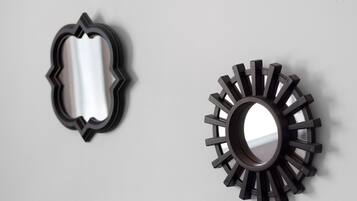 Two wall-mounted mirrors with unique shapes and designs.