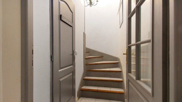 A narrow hallway with a staircase leading to a landing.