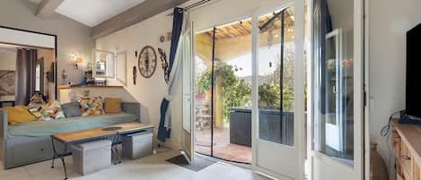 Un salon avec un canapé, une table basse et un téléviseur.
