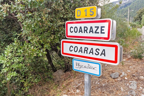 A road sign with the names 'COARAZE' and 'COARASA' and a yellow sign with 'D 15'.