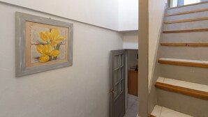 Una escalera con peldaños de madera y una puerta gris.