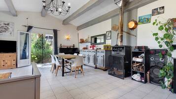Une cuisine spacieuse avec un coin repas, une grande fenêtre et un barbecue intégré.