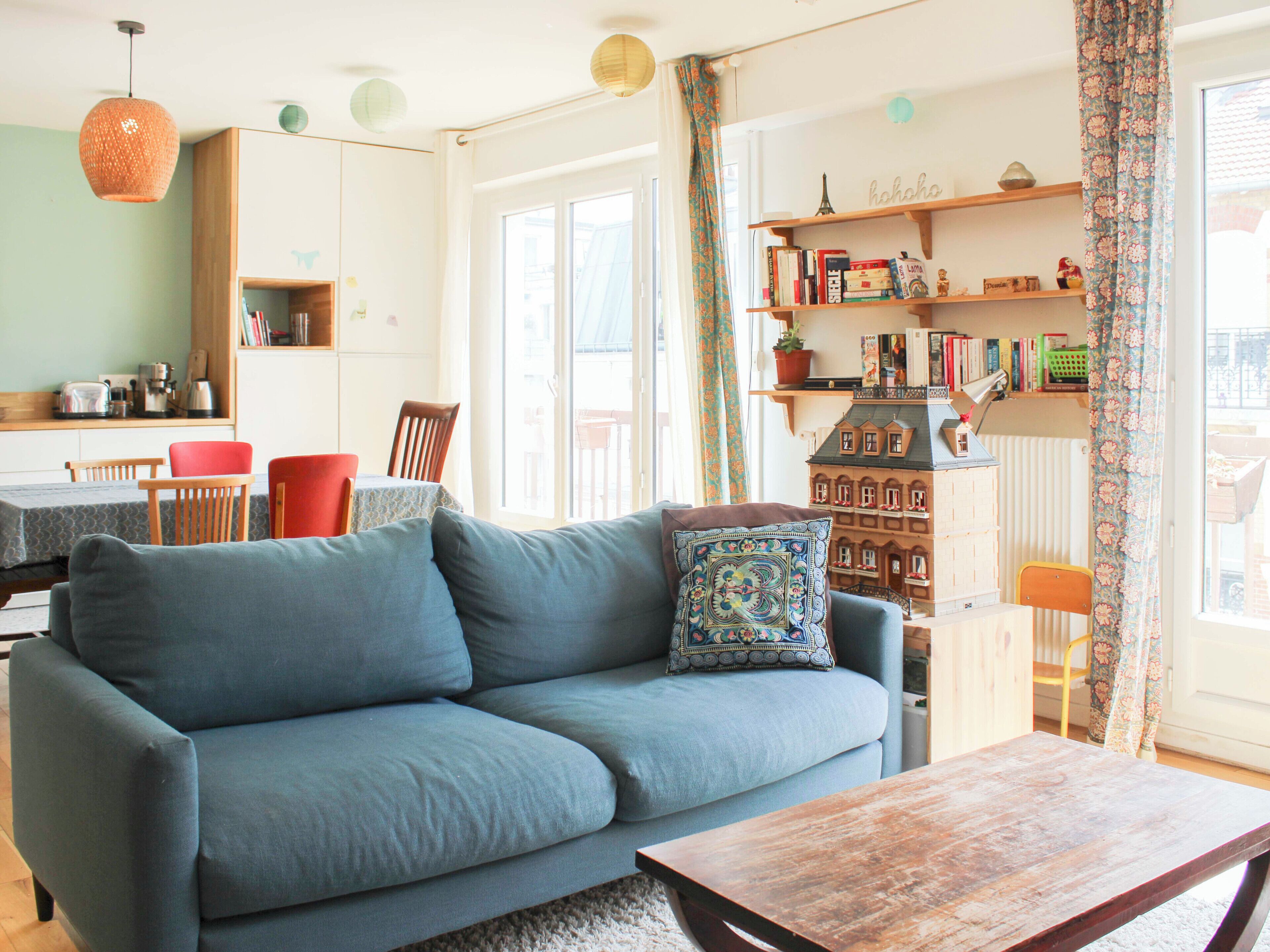 A living room with a sofa, a wooden coffee table, and a bookshelf.