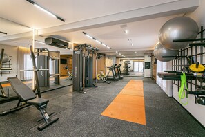 A gym with various exercise equipment, including treadmills, weight machines, and a rowing machine. - 350m from Beira-Mar | Pool | Gym #CA103 (Florianópolis)