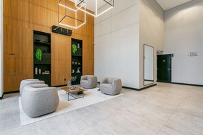 Un área de recepción moderna con un muro de paneles de madera, un mostrador de recepción y asientos.