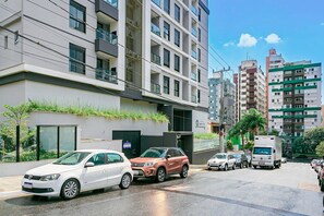 Ein mehrstöckiges Gebäude mit modernem Design, das Balkone und große Fenster aufweist.