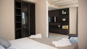 A hotel room with a bed, a seating area with a TV, and a wardrobe. - Torre with pool and lake-view terraces in Gargnano (Gargnano)