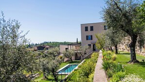 A modern building with a pool, surrounded by well-maintained gardens and olive trees. - Torre with pool and lake-view terraces in Gargnano (Gargnano)