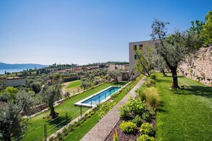 A residential property with a swimming pool, lush greenery, and a view of the sea. - Torre with pool and lake-view terraces in Gargnano (Gargnano)