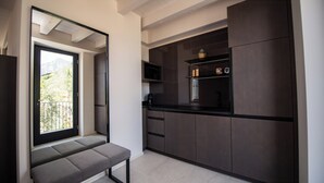 A modern kitchen with dark cabinetry, a built-in microwave, and a bench by the window. - Torre with pool and lake-view terraces in Gargnano (Gargnano)
