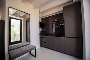 Eine moderne Küche mit dunklen Schränken, einer eingebauten Mikrowelle und einer Sitzbank am Fenster.