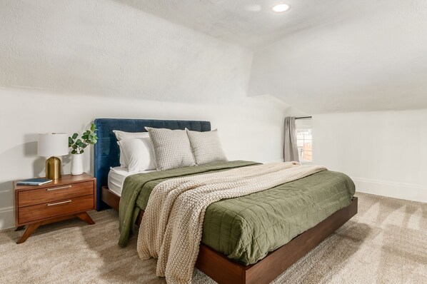 A bedroom with a bed, bedside table, lamp, and a window. - Spacious & Historic 3BR Near German Village. Fire Pit, Yard, Grill.Veteran-Owned (Columbus)