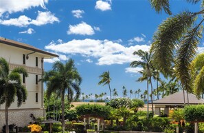 A resort with a white building, palm trees, and a clear blue sky. - Beachfront 2 Condos at Ko Olina Beach Villas · 6 BR · Sleeps 16 (Kapolei)