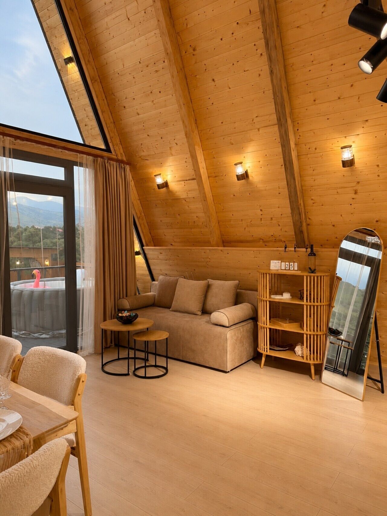 Une pièce chaleureuse, avec un plancher en bois, un canapé, une petite table et un miroir.