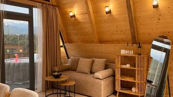 Une pièce chaleureuse, avec un plancher en bois, un canapé, une petite table et un miroir.