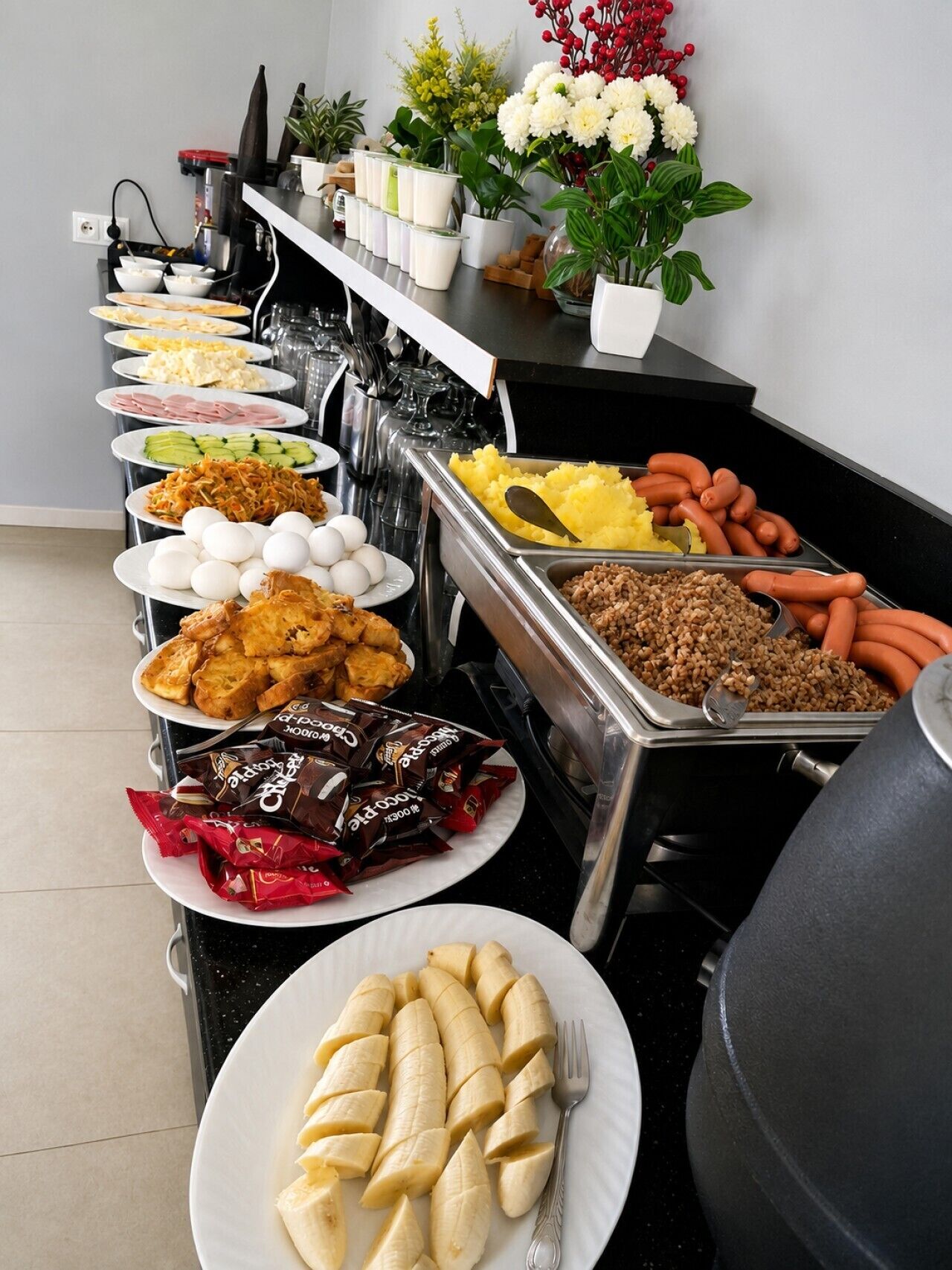 Un buffet proposant une variété de plats, notamment des œufs, de la viande et des en-cas.