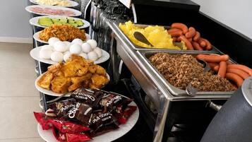 Un buffet proposant une variété de plats, notamment des œufs, de la viande et des en-cas.