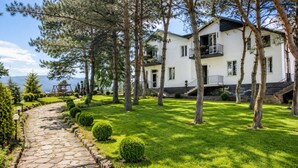 A two-story building with a stone pathway leading to the entrance, surrounded by well-maintained grass and trees. - Pine Garden Boutique Hotel and Pool in Stepanavan (Stepanavan)
