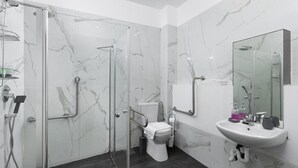 Une salle de bain moderne avec une douche à parois de verre, des toilettes blanches et un mur recouvert de carreaux de marbre.