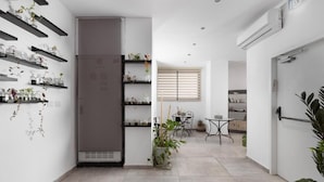 Une cuisine moderne dotée d’étagères intégrées, un coin repas avec une table et des chaises, et une plante en pot.