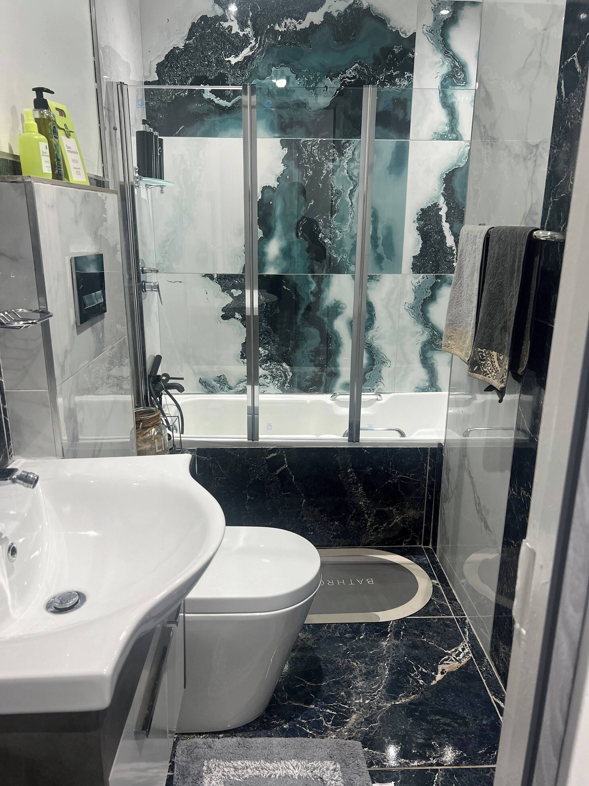 A bathroom with a bathtub, a toilet, a sink, and a shower enclosure.