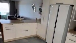 Eine Küche mit weißen Schränken, einem Kühlschrank und einer Arbeitsplatte.